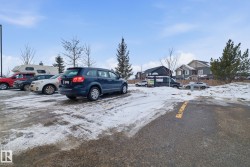 Snow covered parking with uncovered parking and a residential view - 