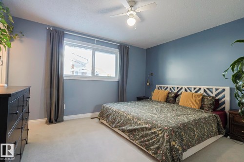 Bedroom with a textured ceiling, light colored carpet, and a ceiling fan - 192 Dunluce Road, Edmonton, AB - Indoor Photo Showing Bedroom