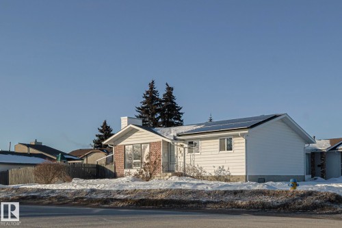 Single story home with roof mounted solar panels, a chimney, and brick siding - 192 Dunluce Road, Edmonton, AB - Outdoor