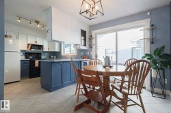 Dining area featuring light tile patterned floors, a textured ceiling, and hanging lights - 