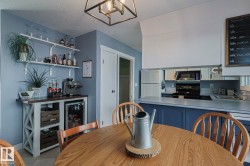 Dining area featuring a dry bar, a textured ceiling, and suspended lighting - 
