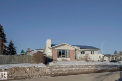 View of front facade with solar panels, a chimney, and brick siding - 