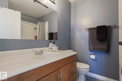 Bathroom with vanity, a shower with shower curtain, and tile patterned flooring - 