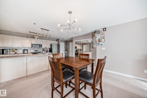 Dining space with suspended lighting and light carpet - 232 530 Hooke Road, Edmonton, AB - Indoor