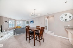 Dining room with light colored carpet and hanging lights - 
