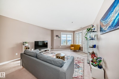 Living room with baseboards and carpet - 232 530 Hooke Road, Edmonton, AB - Indoor Photo Showing Other Room