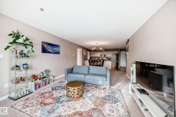 Living area featuring light colored carpet and suspended lighting - 