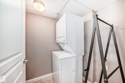 Laundry room featuring a drop ceiling and stacked washing machine and dryer - 