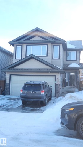 Traditional-style house with an attached garage, stone siding, and driveway - 31 Newgate Way, St. Albert, AB - Outdoor