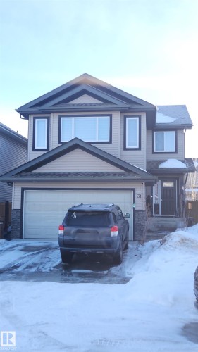 View of front of home featuring stone siding, a garage, and concrete driveway - 31 Newgate Way, St. Albert, AB - Outdoor