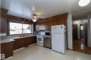 Kitchen with white appliances, light countertops, a ceiling fan, light flooring, and backsplash - 9020 152 Avenue, Edmonton, AB  - Indoor Photo Showing Kitchen With Double Sink 