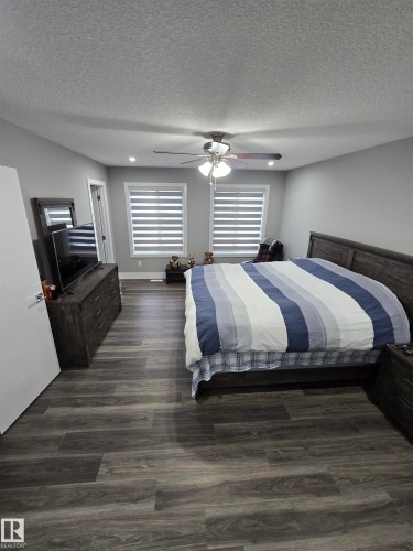 Master Bedroom with dark wood finished floors, a textured ceiling, ceiling fan, and recessed lighting - 1641 Enright Way Nw, Edmonton, AB - Indoor Photo Showing Bedroom