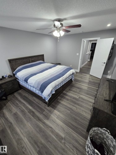 Bedroom featuring a textured ceiling, ceiling fan, and dark wood finished floors - 1641 Enright Way Nw, Edmonton, AB - Indoor Photo Showing Bedroom