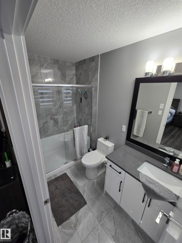 Bathroom featuring vanity, a stall shower, and a textured ceiling - 1641 Enright Way Nw, Edmonton, AB - Indoor Photo Showing Bathroom