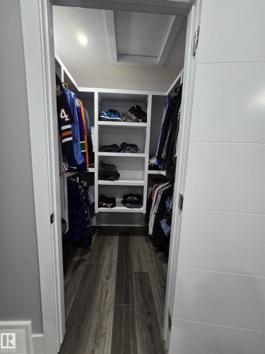 Walk in closet featuring dark wood-type flooring and attic access - 1641 Enright Way Nw, Edmonton, AB - Indoor With Storage