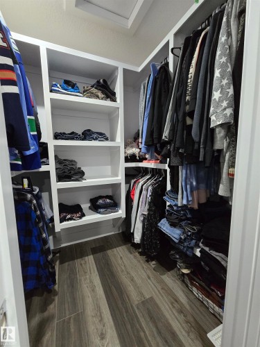 Walk in closet featuring dark wood-style floors and attic access - 1641 Enright Way Nw, Edmonton, AB - Indoor With Storage