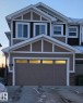 View of front of property with stone siding, concrete driveway, and board and batten siding - 1641 Enright Way Nw, Edmonton, AB  - Outdoor 