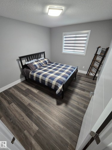 Bedroom featuring dark wood finished floors and a textured ceiling - 1641 Enright Way Nw, Edmonton, AB - Indoor Photo Showing Bedroom