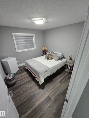 Bedroom with a textured ceiling and wood finished floors - 1641 Enright Way Nw, Edmonton, AB - Indoor Photo Showing Bedroom