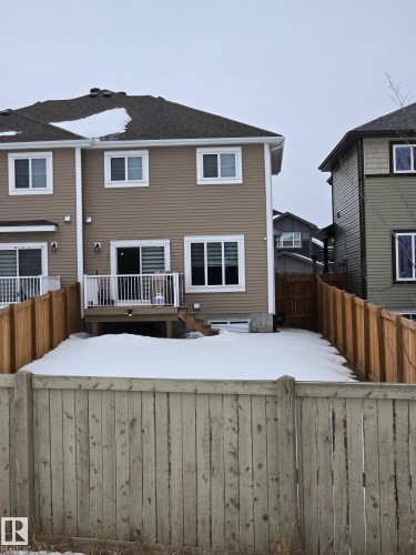 Snow covered house featuring a fenced backyard and a wooden deck - 1641 Enright Way Nw, Edmonton, AB - Outdoor With Deck Patio Veranda With Exterior