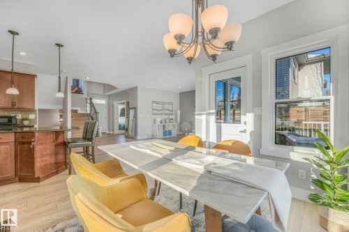 Dining space with light wood-type flooring, a chandelier, stairs, and recessed lighting - 2307 Rutherford Way, Edmonton, AB - Indoor Photo Showing Dining Room