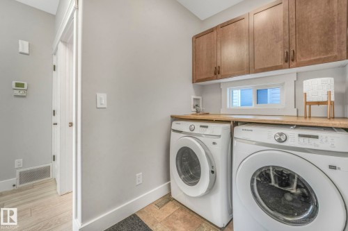 Washroom featuring cabinet space and washing machine and dryer - 2307 Rutherford Way, Edmonton, AB - Indoor Photo Showing Laundry Room
