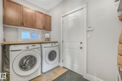 Laundry area featuring independent washer and dryer, stone finish flooring, and cabinet space - 