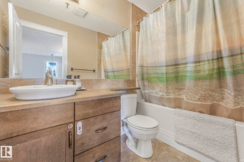 Full bath with shower / tub combo with curtain, vanity, and light tile patterned flooring - 2307 Rutherford Way, Edmonton, AB - Indoor Photo Showing Bathroom