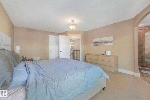 Carpeted bedroom featuring arched walkways and baseboards - 2307 Rutherford Way, Edmonton, AB - Indoor Photo Showing Bedroom