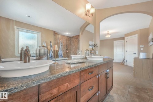 Bathroom featuring a marble finish shower, double vanity, and light colored carpet - 2307 Rutherford Way, Edmonton, AB - Indoor Photo Showing Bathroom