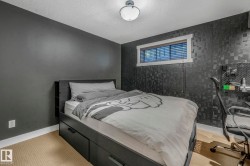 Bedroom with an accent wall, a textured ceiling, carpet flooring, and an office area - 