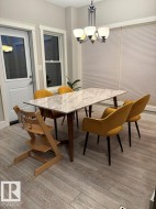 Dining room featuring light wood-type flooring and a chandelier - 