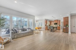 Living room with recessed lighting, light wood-style flooring, and a chandelier - 