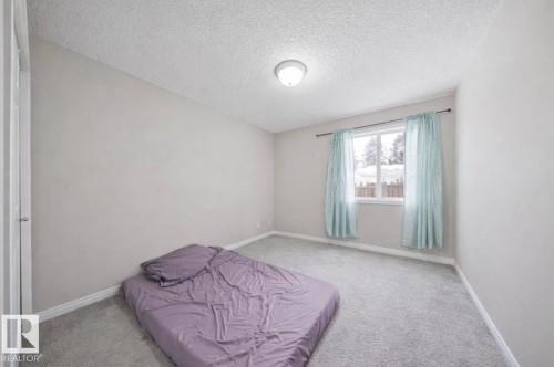 Unfurnished bedroom featuring a textured ceiling and carpet floors - 103 12110 119 Ave, Edmonton, AB - Indoor Photo Showing Bedroom