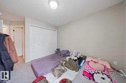 Unfurnished bedroom with carpet floors, a textured ceiling, and a closet - 