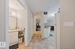 Hallway featuring a textured ceiling and a sink - 