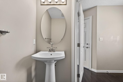 Bathroom with dark wood-type flooring and a textured ceiling - 2338 Casselman Crescent, Edmonton, AB - Indoor Photo Showing Bathroom