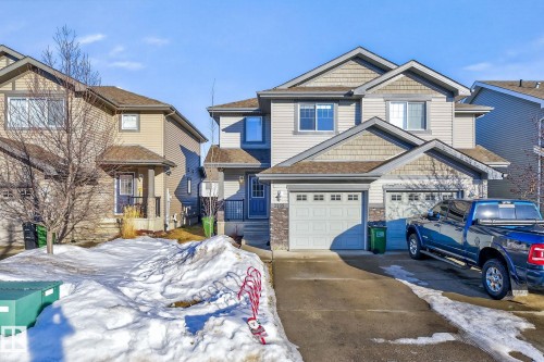 Craftsman-style house featuring a shingled roof, concrete driveway, and a garage - 2338 Casselman Crescent, Edmonton, AB - Outdoor With Facade