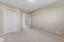 Unfurnished bedroom featuring carpet flooring, a textured ceiling, and a closet - 