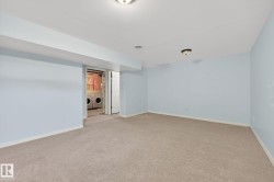 Empty room featuring light colored carpet and washer and dryer - 
