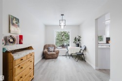Living area with light wood-type flooring and a textured ceiling - 