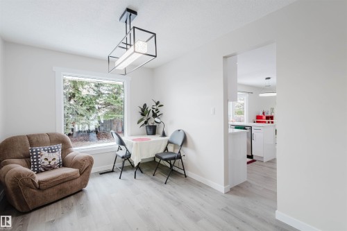Living area with light wood-style flooring and baseboards - 10423 35 Avenue, Edmonton, AB - Indoor Photo Showing Living Room
