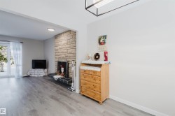 Living room with light wood-style floors and a large fireplace - 