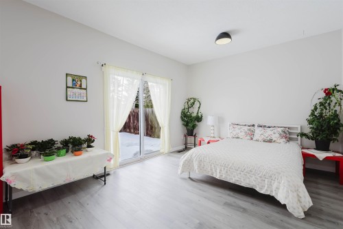 Bedroom featuring access to outside and wood finished floors - 10423 35 Avenue, Edmonton, AB - Indoor Photo Showing Bedroom