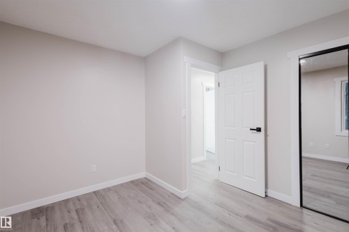 Unfurnished bedroom with baseboards and light wood-style flooring - 10423 35 Avenue, Edmonton, AB - Indoor Photo Showing Other Room