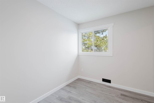 Unfurnished room featuring baseboards and light wood finished floors - 10423 35 Avenue, Edmonton, AB - Indoor Photo Showing Other Room