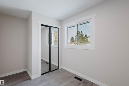 Unfurnished bedroom featuring a closet, light wood-style flooring, and a textured ceiling - 10423 35 Avenue, Edmonton, AB - Indoor Photo Showing Other Room