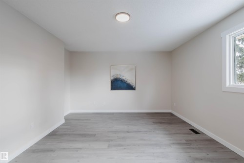 Unfurnished room featuring light wood-type flooring and baseboards - 10423 35 Avenue, Edmonton, AB - Indoor Photo Showing Other Room