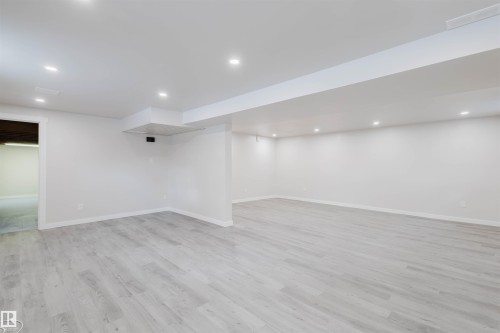 Finished below grade area with recessed lighting and light wood finished floors - 10423 35 Avenue, Edmonton, AB - Indoor