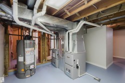 Utility room featuring gas water heater and heating unit - 